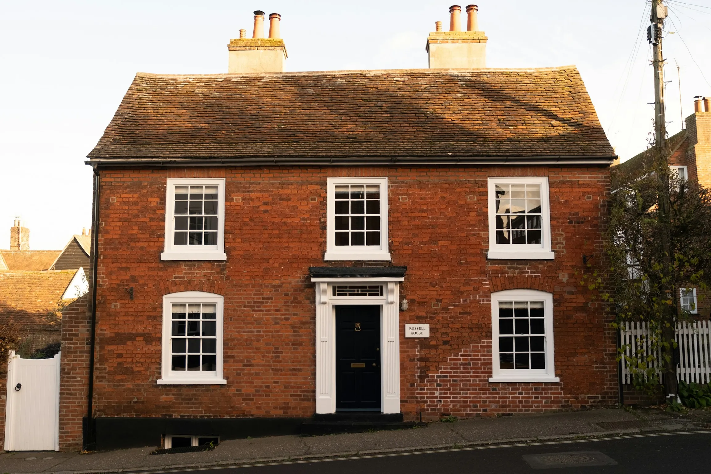 A Georgian red-brick house with a black front door and white sash windows